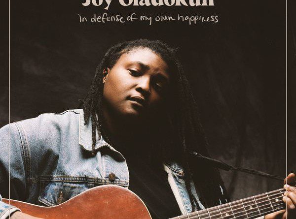 Album cover photo of Joy Oladokun holding an acoustic guitar