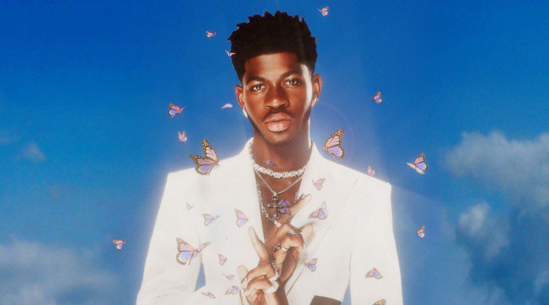 Lil nas X with a sky blue background, wearing a white suit. He has a glowing aura and butterflies surrounding him